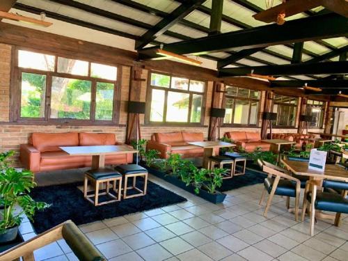 um restaurante com sofás, mesas e plantas em San José Del Valle em Valle de Bravo