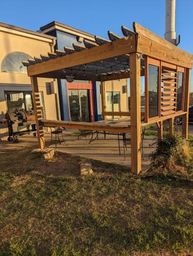 a wooden pergola sitting outside of a building at Executive Inn and Suites Wichita Falls in Wichita Falls