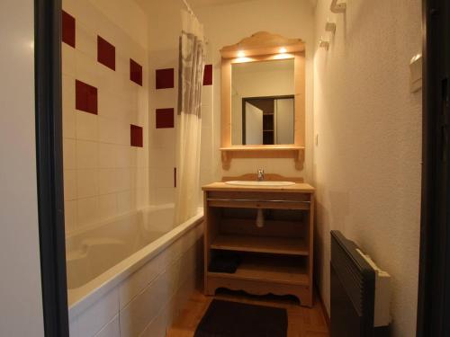 a bathroom with a sink and a tub and a mirror at Appartement Puy-Saint-Vincent, 2 pièces, 6 personnes - FR-1-330G-76 in Puy-Saint-Vincent