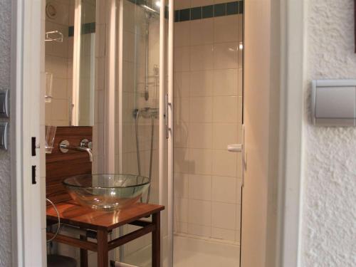 a bathroom with a glass bowl on a table and a shower at Appartement Vars, 1 pièce, 2 personnes - FR-1-330B-149 in Vars