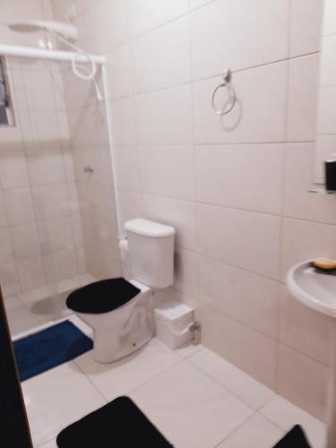 uma casa de banho com um WC, um chuveiro e um lavatório. em Lindo Flat em Maresias em São Sebastião