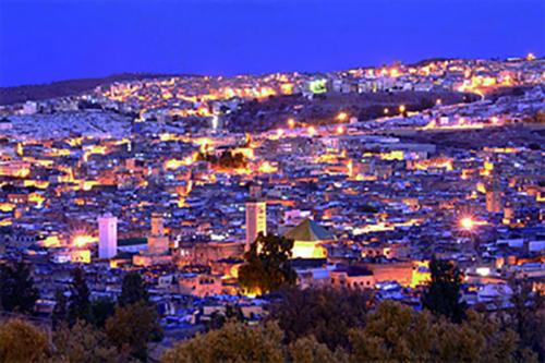 a view of a city lit up at night at Appartement meublé in Fez