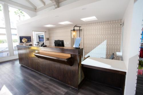 an office with a wooden reception desk with a mirror at Vagabond Inn Glendale in Glendale