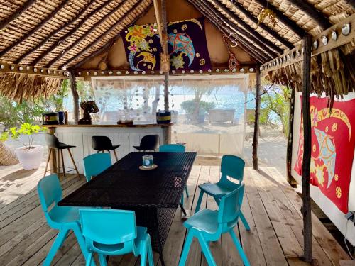 - une table à manger et des chaises dans une tente dans l'établissement ONLY YOU MOTU, à Bora Bora