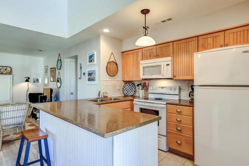 a kitchen with wooden cabinets and a white refrigerator at Courtside 1640 in Seabrook Island
