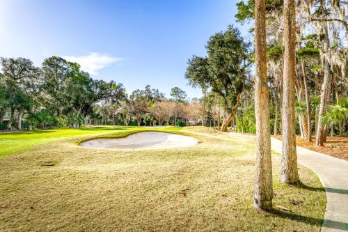 a golf course with palm trees in the foreground at Courtside 1640 in Seabrook Island
