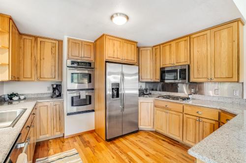 a kitchen with wooden cabinets and stainless steel appliances at House on HoneyBee Hill in Lakebay