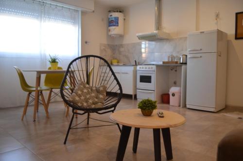 una pequeña cocina con mesa, silla y mesa en Departamento moderno y luminoso en Olavarría
