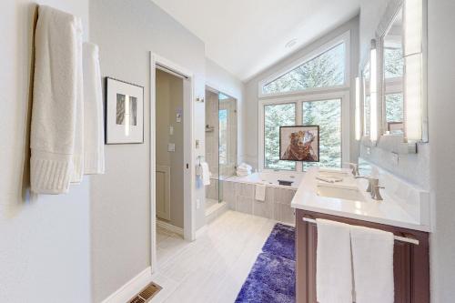 a white bathroom with a sink and a mirror at Stone Creek Fairway in Avon