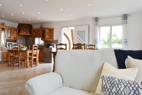 a living room with a white couch and a kitchen at Casa da Piedade, a Home in Madeira in Ponta do Sol