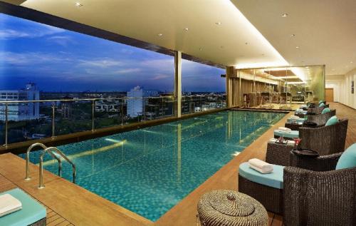 a hotel swimming pool with a view of a city at Vivanta Kolkata EM Bypass in Kolkata