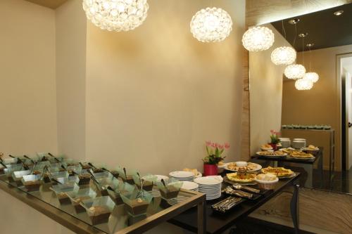 a buffet table with food on it with chandeliers at Hotel Lancaster in Turin