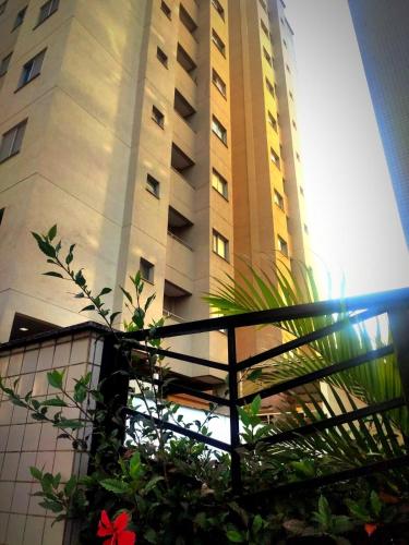 wysoki budynek z rośliną przed nim w obiekcie Aconchego Poços de Caldas w mieście Poços de Caldas