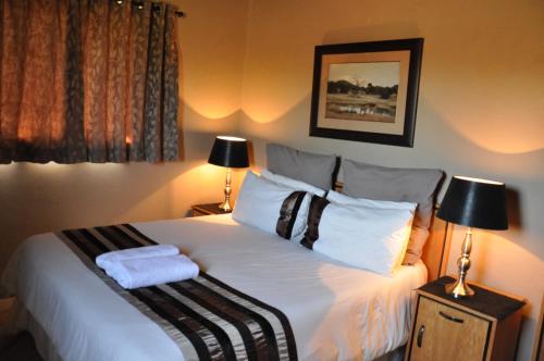 a bedroom with a bed with two towels on it at Ukutula Lion Lodge in Brits
