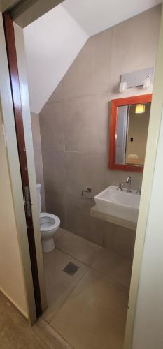 uma casa de banho com um lavatório, um WC e um espelho. em La Quinta Apart em Cruz del Eje