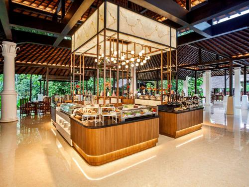 een restaurant met een bar met tafels en stoelen bij Novotel Bogor Golf Resort in Bogor
