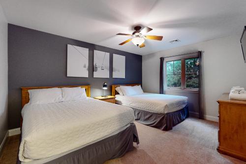 um quarto com 2 camas e uma ventoinha de tecto em 6 Fieldstone Ct em Lake Harmony
