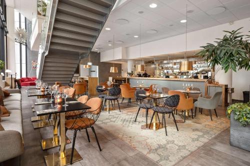 a restaurant with tables and chairs and a bar at Best Western Malmo Arena Hotel in Malmö