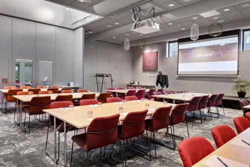 a conference room with tables and chairs and a projection screen at Best Western Malmo Arena Hotel in Malmö