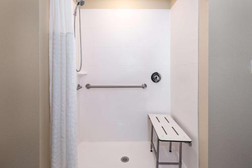 a white shower with a bench in a bathroom at Ameniti Bay - Best Western Signature Collection in Sarasota