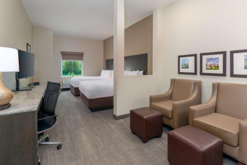 a hotel room with a bed and a desk and chairs at Ameniti Bay - Best Western Signature Collection in Sarasota