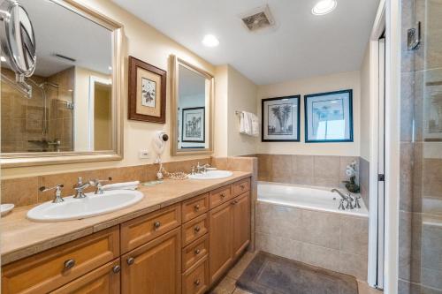 a bathroom with two sinks and a tub and a shower at Portofino Island Resort & Spa 1-2003 in Pensacola Beach