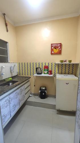 a small kitchen with a sink and a refrigerator at Angel Hospedagem de quartos in Vila Velha