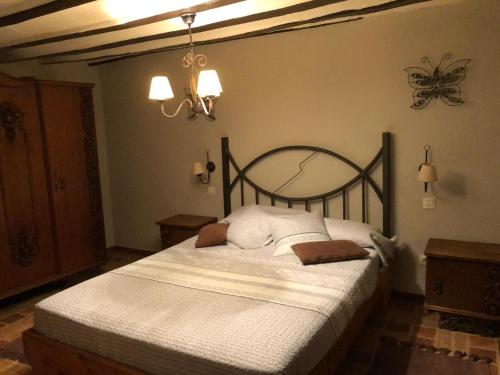 a bedroom with a large bed with white sheets at PUENTECUERVO BAJO in Pancorbo