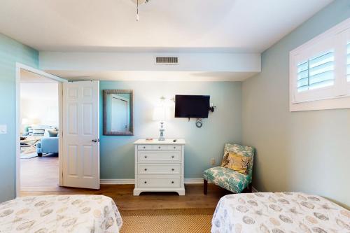 een slaapkamer met een bed, een tv en een stoel bij The Islander 205 in Destin