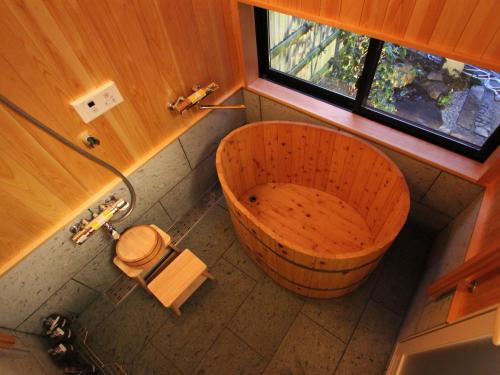 a bathroom with a wooden tub and a toilet at Brian Machiya Inn in Kyoto