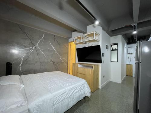 a bedroom with a bed and a wall with a tv at Edificio Helena in Medellín