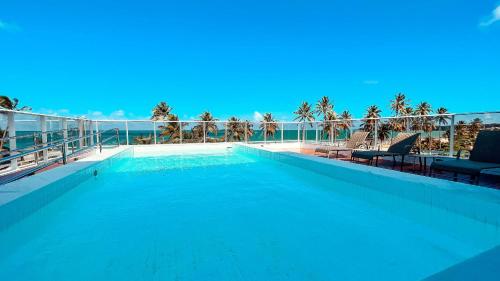 uma grande piscina no topo de um edifício em Puerto Ventura Cabo Branco Beira-mar Genius Flats em João Pessoa