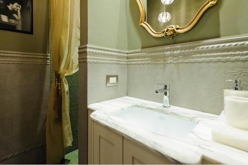 a bathroom with a white sink and a mirror at B&B Balsimelli12 in San Marino