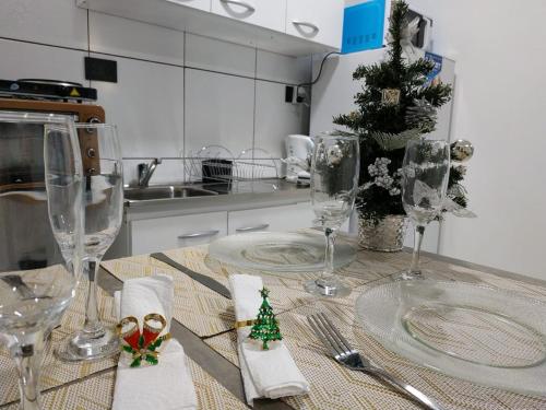 a kitchen with a table with wine glasses and christmas decorations at Tres Fronteras Apart 1 in Puerto Iguazú