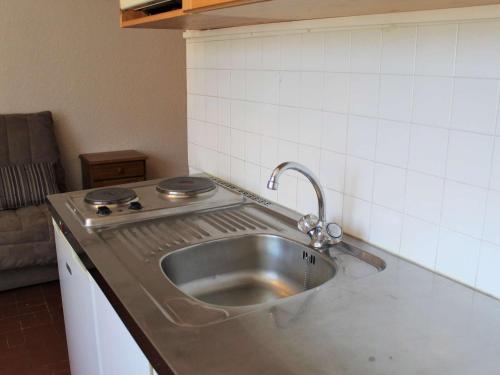 eine Edelstahlspüle in einer Küche mit einem Herd in der Unterkunft Appartement Vars, 1 pièce, 2 personnes - FR-1-330B-111 in Vars