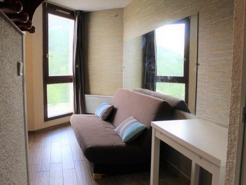 a living room with a couch and two windows at Appartement Vars, 1 pièce, 2 personnes - FR-1-330B-119 in Vars