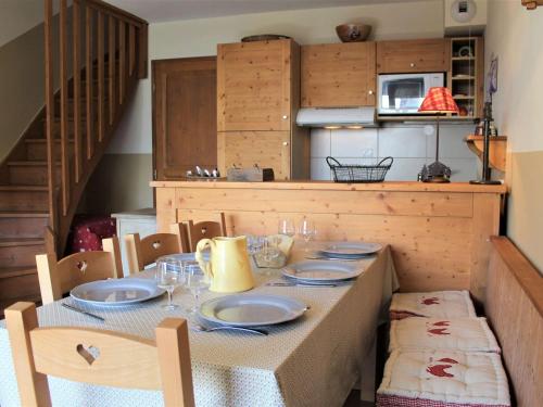 une table avec des assiettes et des verres au-dessus dans l'établissement Duplex 3 pièces avec piscine, 6 couchages, à 50m des pistes - Quartier Fontbonne, Vars - FR-1-330B-117, à Vars