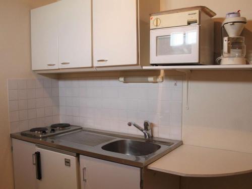 une petite cuisine avec un évier et un micro-ondes dans l'établissement Studio 4 Pers, Pied des Pistes, Proche Commerces - Vars Les Claux - FR-1-330B-132, à Vars
