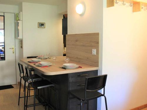 une cuisine avec un comptoir et des chaises autour de la cuisine dans l'établissement Appartement au cœur de Vars les Claux, 2 pièces, 4 couchages, proche pistes et commerces - FR-1-330B-129, à Vars