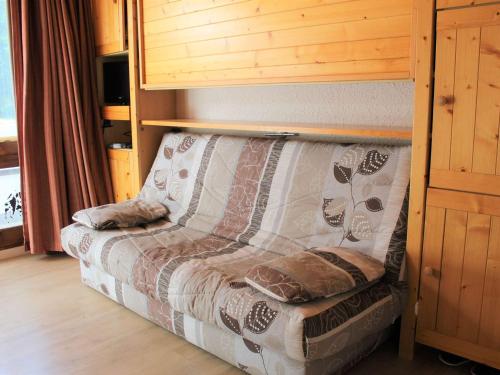 un lit dans une chambre avec un mur en bois dans l'établissement Studio cosy à Vars Les Claux, accès direct aux pistes, balcon sud - FR-1-330B-131, à Vars