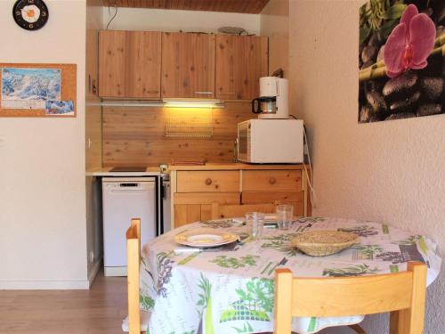 une petite cuisine avec une table et une cuisine avec une table et des chaises dans l'établissement Studio cosy à Vars Les Claux, accès direct aux pistes, balcon sud - FR-1-330B-131, à Vars