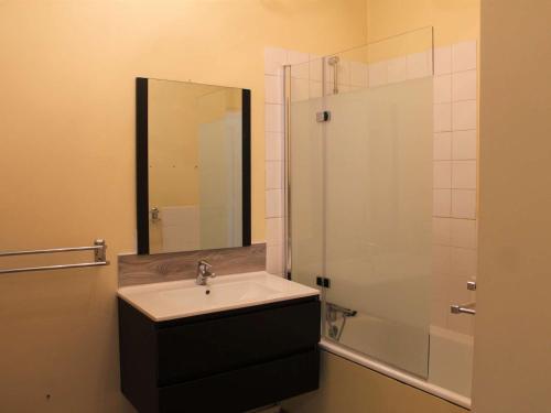 uma casa de banho com um lavatório e um chuveiro com um espelho. em Appartement Vars, 2 pièces, 6 personnes - FR-1-330B-98 em Vars