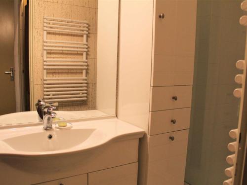 La salle de bains blanche est pourvue d'un lavabo et d'un miroir. dans l'établissement Appartement Vars, 1 pièce, 4 personnes - FR-1-330B-115, à Vars