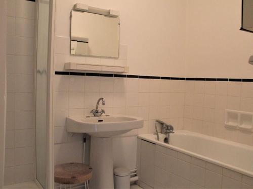 a white bathroom with a sink and a bath tub at Appartement Vars, 3 pièces, 8 personnes - FR-1-330B-141 in Vars