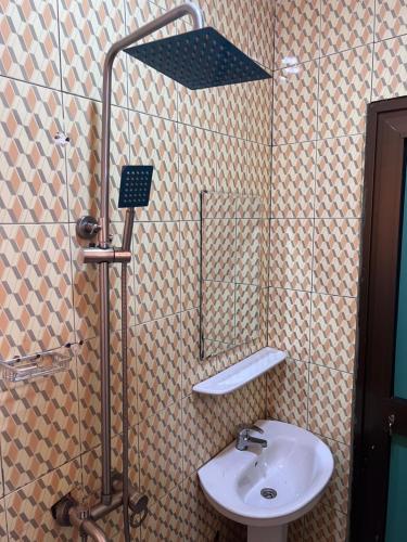 a bathroom with a sink and a shower with a mirror at Ouedraogo Property Management in Ouagadougou