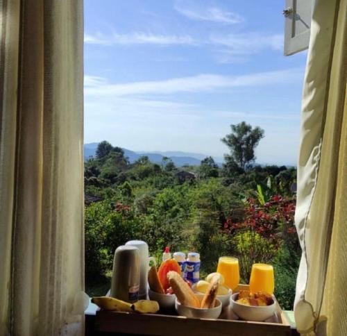 een raam met eten op een tafel met uitzicht bij Chalés Lavras de Minas - Amar in Lavras Novas