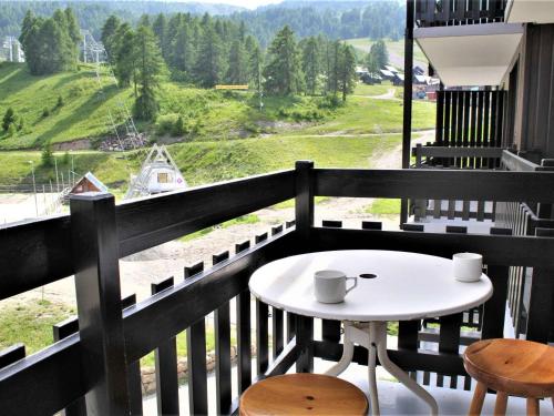d'une table blanche et de deux chaises sur un balcon avec vue. dans l'établissement Appartement cosy 2 pièces, 6 couchages, pied des pistes, Risoul 1850 - FR-1-330-495, à Risoul