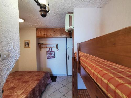 Zimmer mit einem Bett und einem Flur mit einer Tür in der Unterkunft Studio Saint-Michel-de-Chaillol, 1 pièce, 4 personnes - FR-1-393-142 in Saint-Michel-de-Chaillol