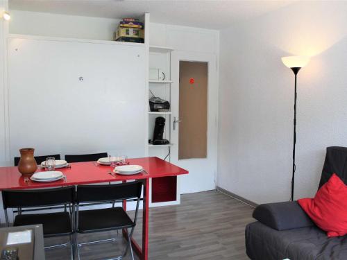 - un salon avec une table rouge et un canapé dans l'établissement Appartement idéal pour 4 à Vars, proche pistes et commerces, parking inclus - FR-1-330B-94, à Vars