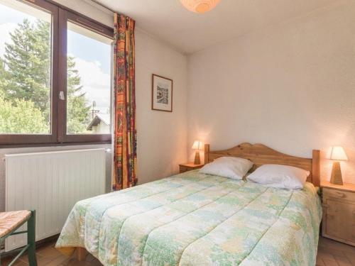 une chambre avec un lit et une grande fenêtre dans l'établissement Charmant 2 pièces à Serre-Chevalier, balcon, parking, 5 pers. - Animaux non admis - FR-1-330E-2, à Saint-Chaffrey